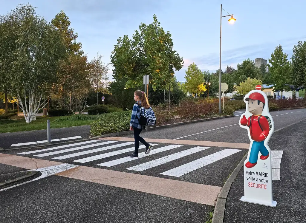 Figurine de signalisation Gamme Éco rétroréfléchissante au bord d'un passage piéton